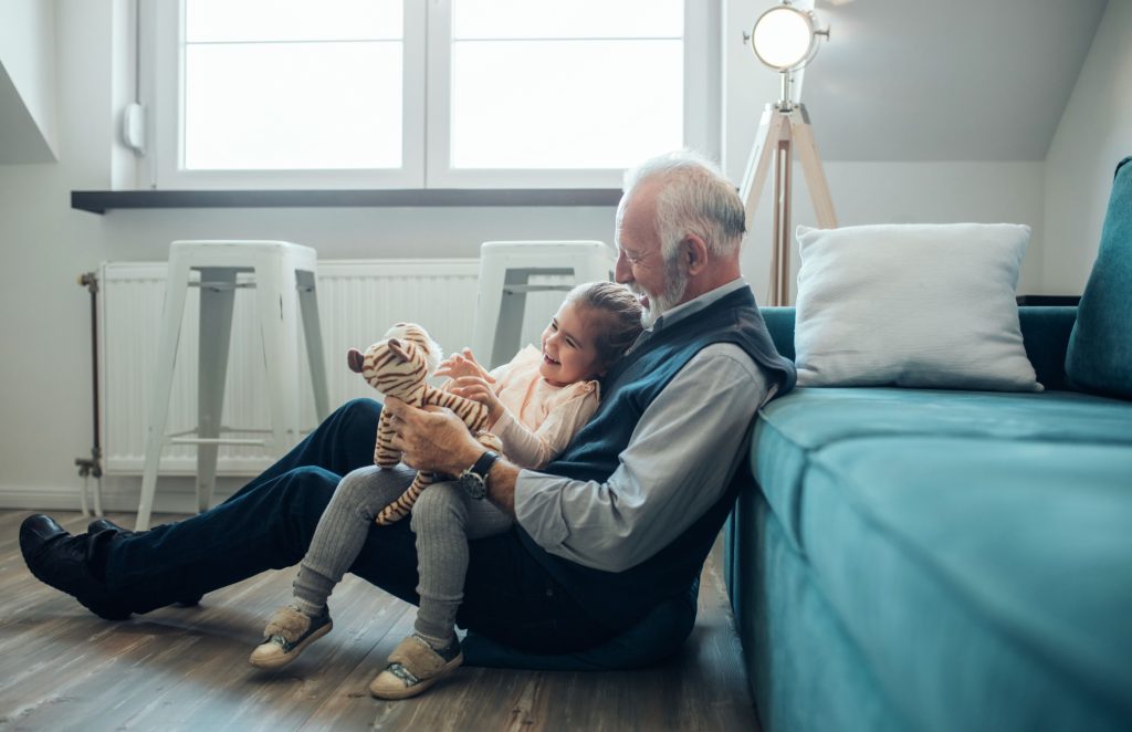 A grandfather playing with his granddaughter.