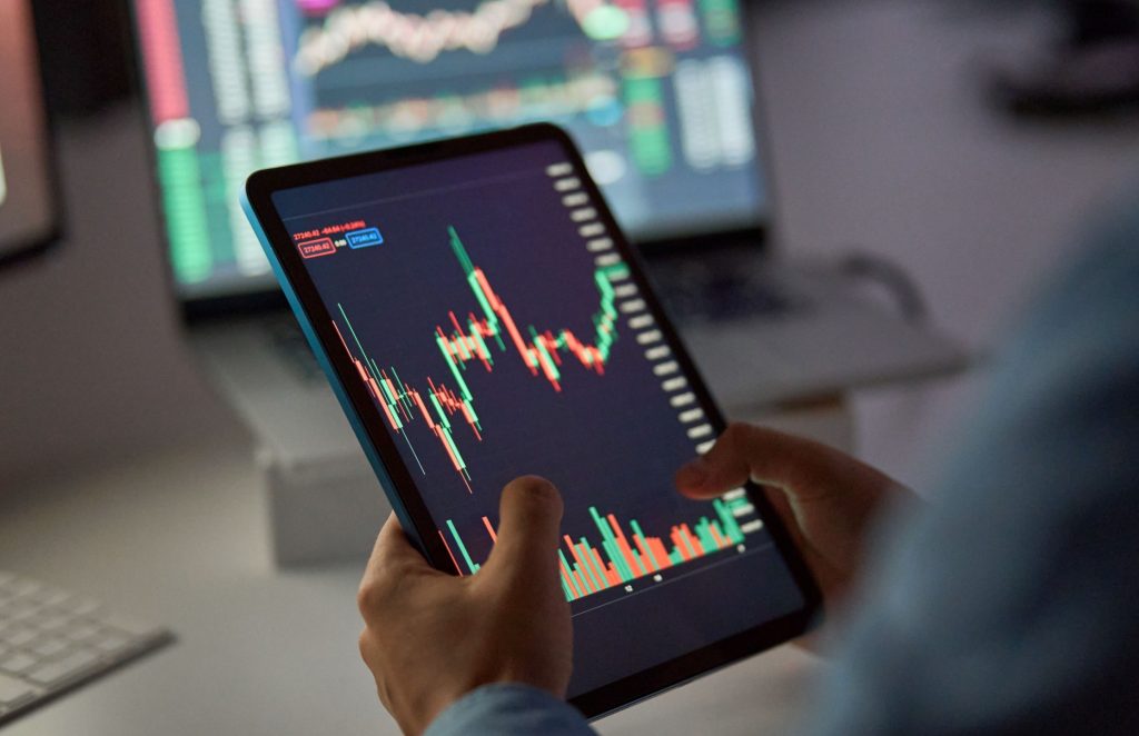 A person looking at a stock market graph on a tablet.